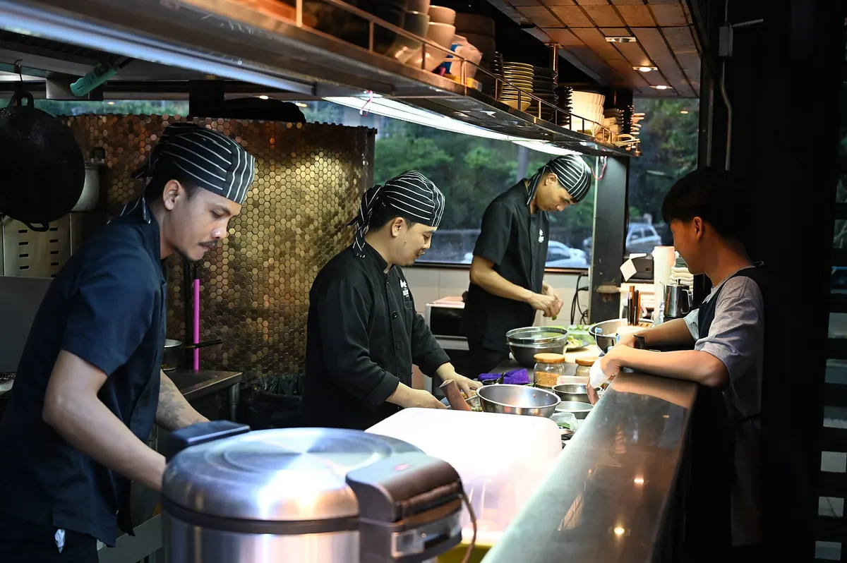 Kitchen staff preparing meals behind a busy restaurant counter