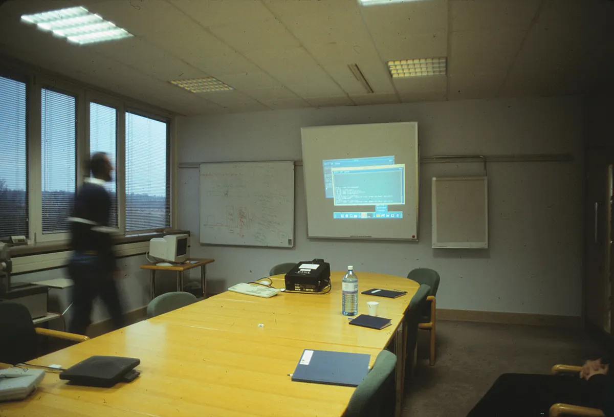 A small office meeting room with a table and screen