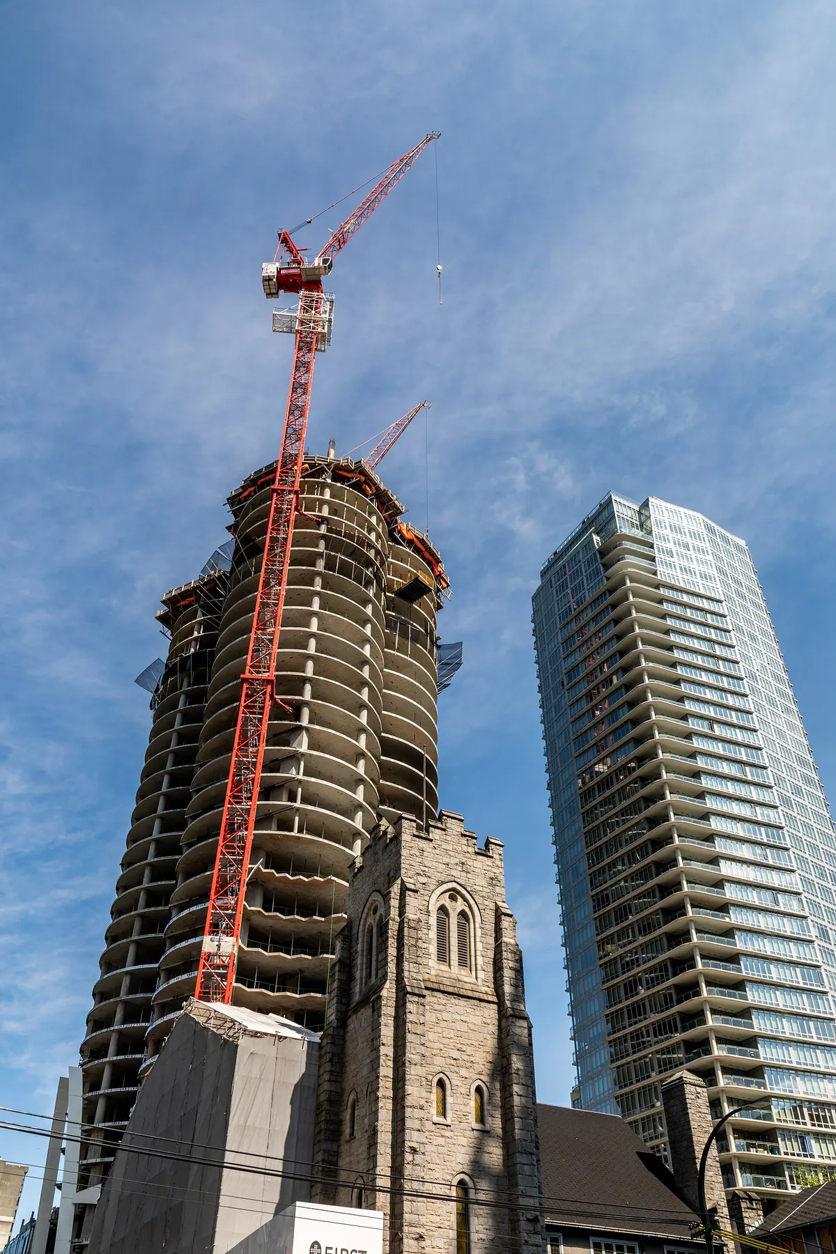 A condo tower under construction with a tower crane in downtown Vancouver